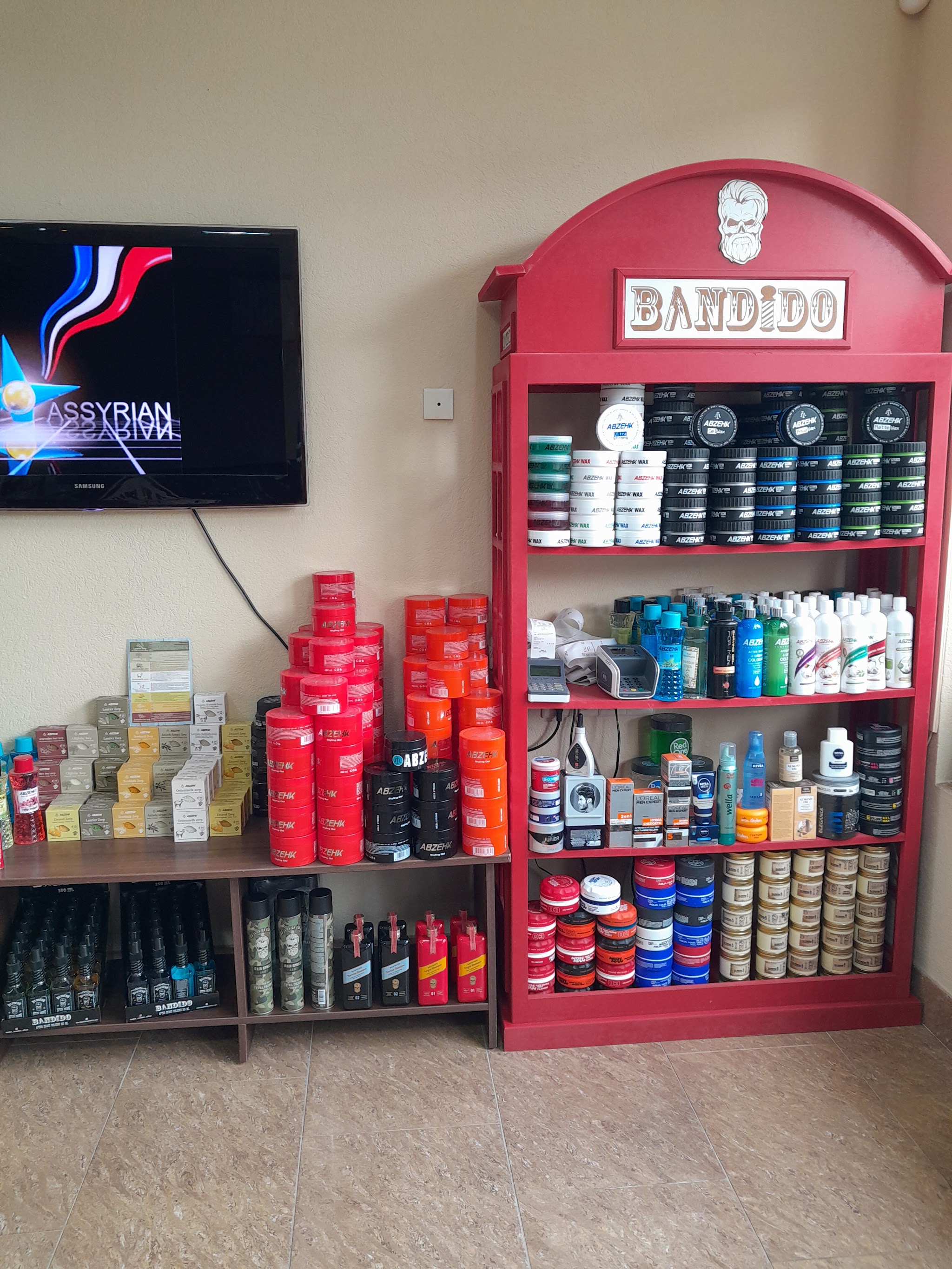 De rode Bandido-kast in de zaak, naast een tafel met rode potten en een televisie aan de muur