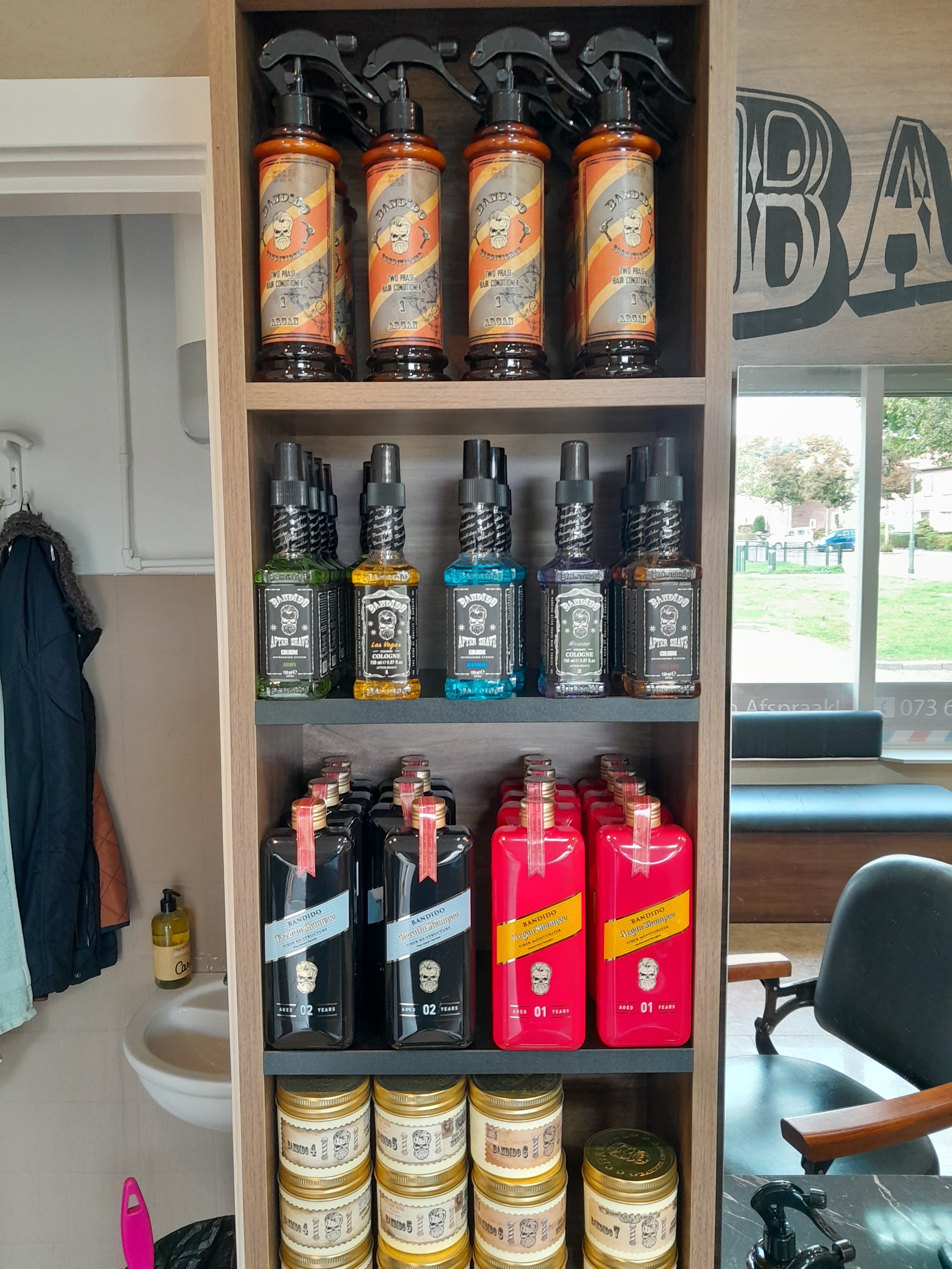 Wandplank met oranje sprayflessen, flesjes en potten